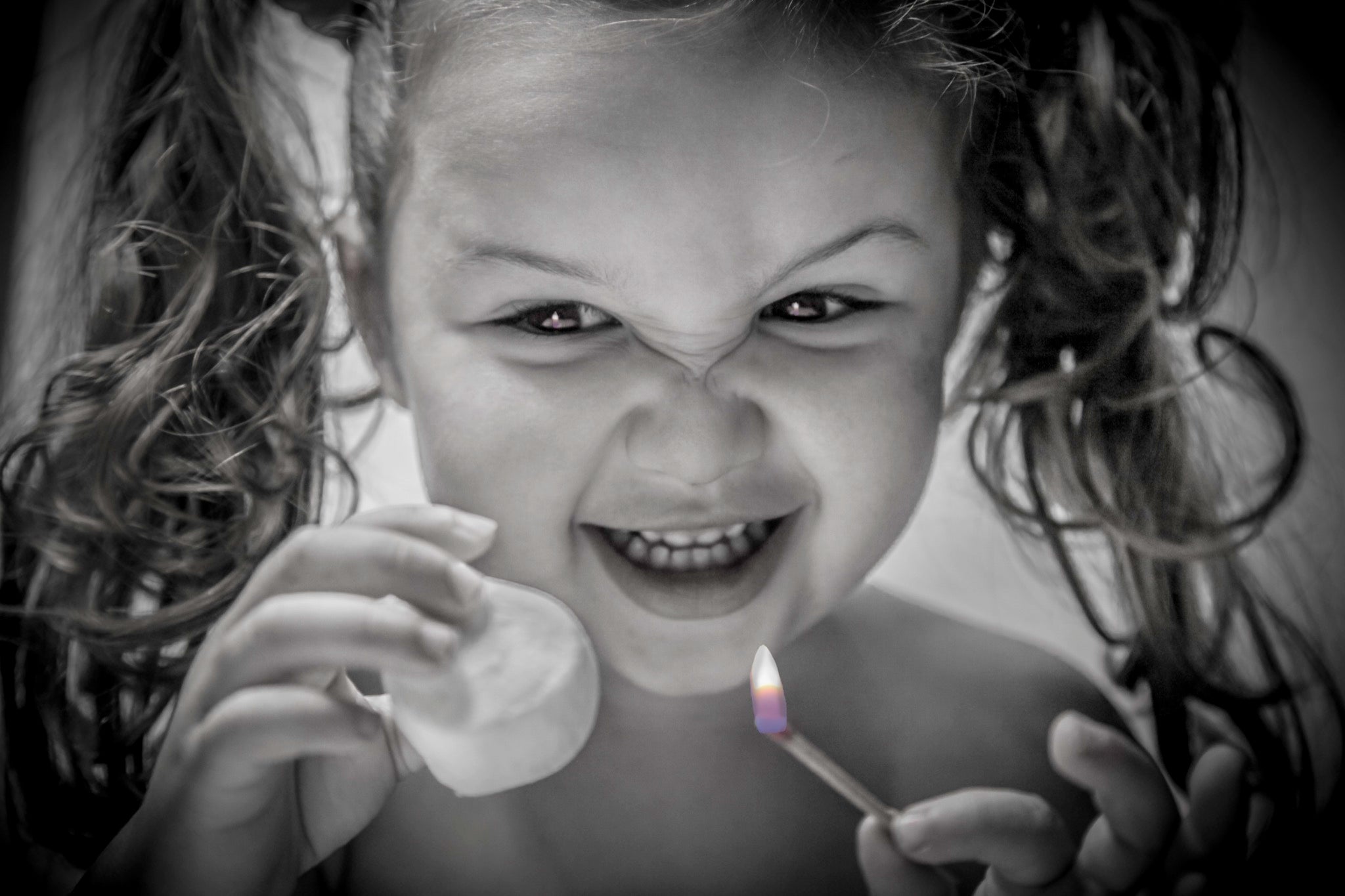 Mischievous child holding a marshmallow and a match with a superimposed flame